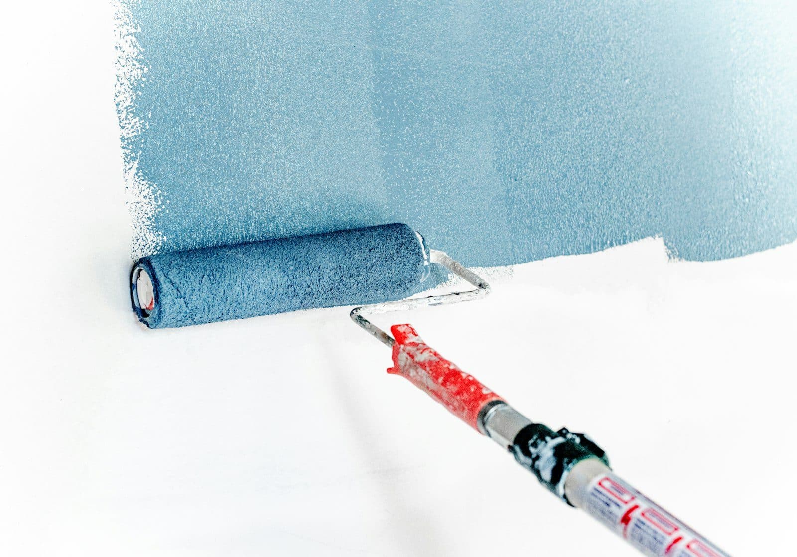 Paint roller laying color on an interior wall