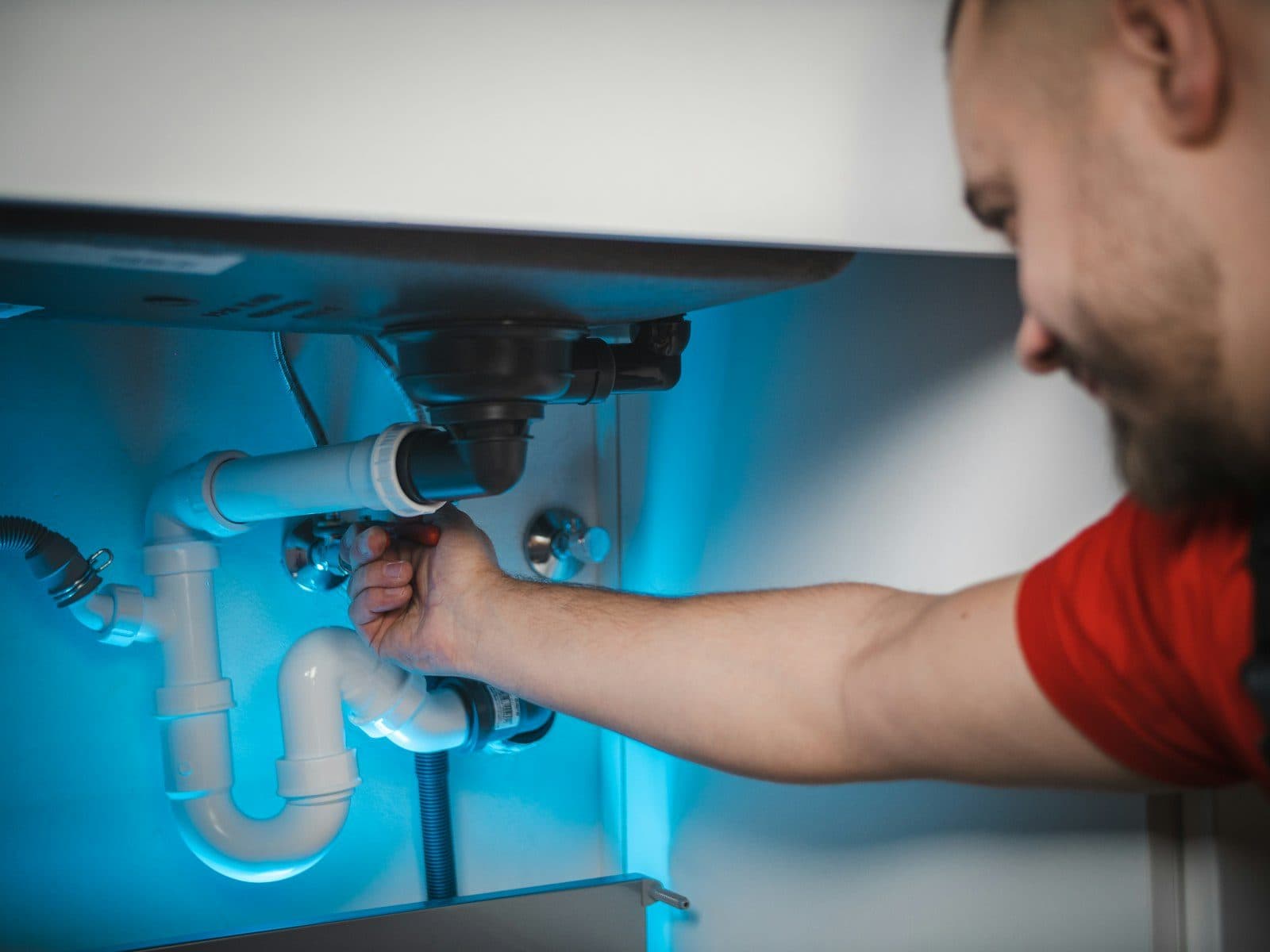 Plumber fitting a pipe in an open wall