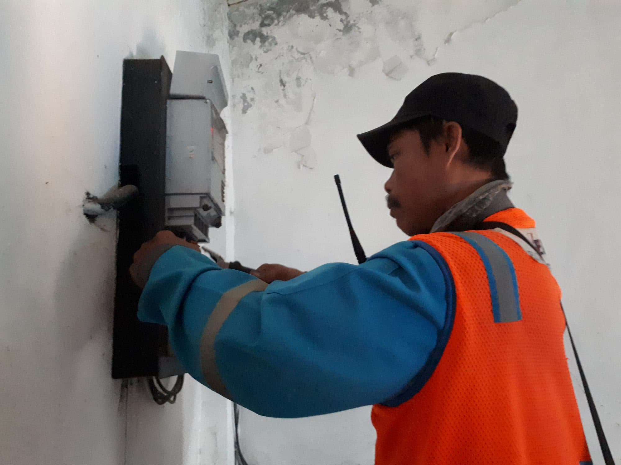 Electrician wiring an electric meter on an exterior wall