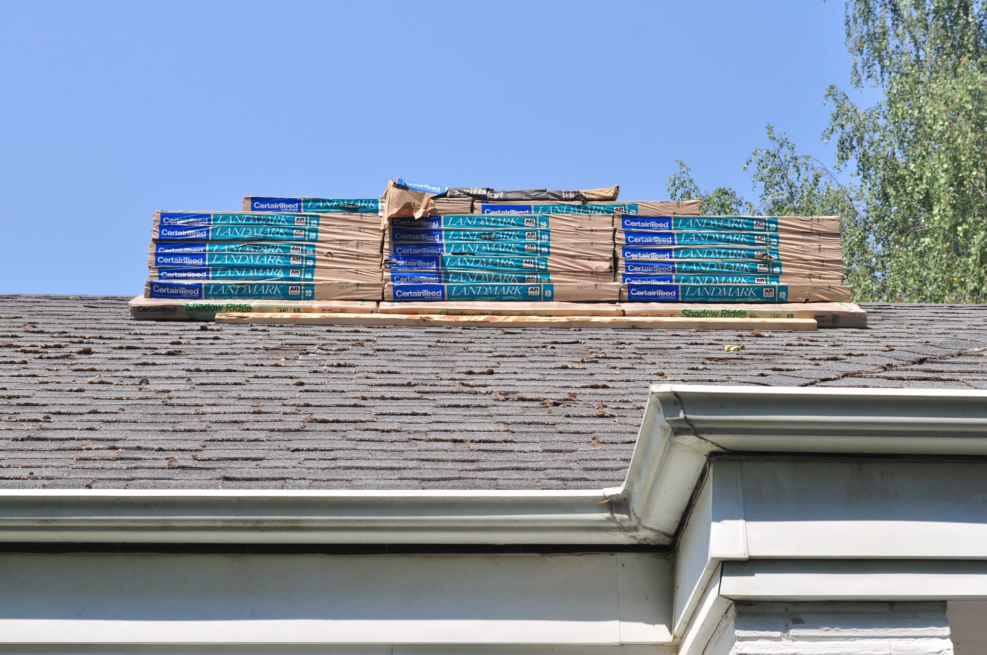 Shingle bundles staged on an asphalt roof